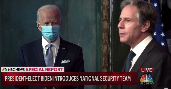 Tổng thống Mỹ Joe Biden đeo khẩu trang, nhìn Ngoại trưởng Antony Blinken phát biểu (ảnh chụp từ video của NBC News/Youtube).