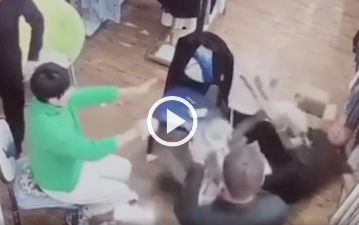 Người đàn ông ngã ngửa xuống nền nhà khi vừa nghe điện thoại vừa cười (ảnh cắt từ clip).